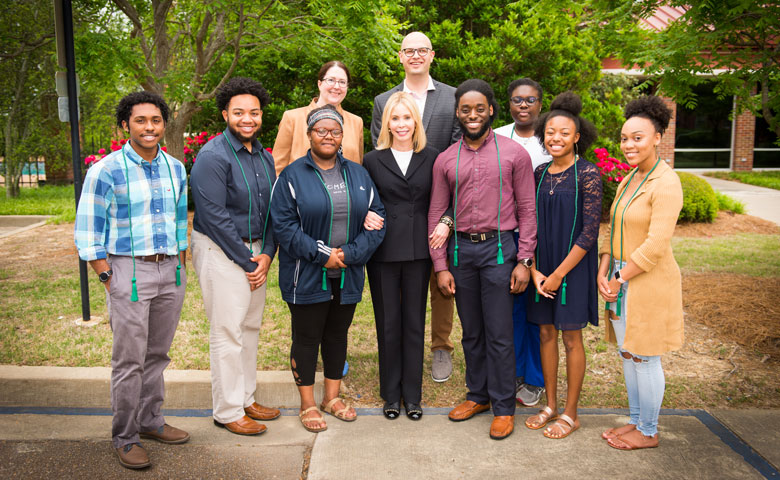 Renvy Pittman (center) enjoys spending time with the Grove Scholars whenever she visits campus. Here, she’s pictured with alumni of the program — the 2018 seniors (from left) Jontae Warren, Devante Yates, Jessica Cole, Rashad Collier, Deshauntra Green, Bre O’Neal and Myrical Taylor. In back are Maura Scully Murry, director of the FASTrack Learning Community, and E. Gray Flora IV, director of Grove Scholars and senior academic mentor for FASTrack.
